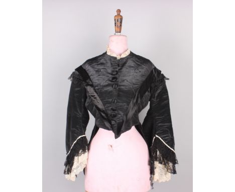 A quantity of 19th century costume, comprising: a black silk jacket trimmed with black and cream lace, a black wool bodice ed