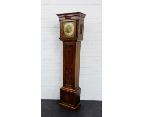 An oak cased Grandmother's clock, with the cornice top over a brass dial with silvered chapter ring and Roman numerals, flank