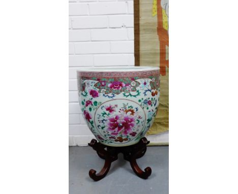 A Chinese Famille Rose floral patterned planter on a shaped hardwood base, 35cm high excluding stand