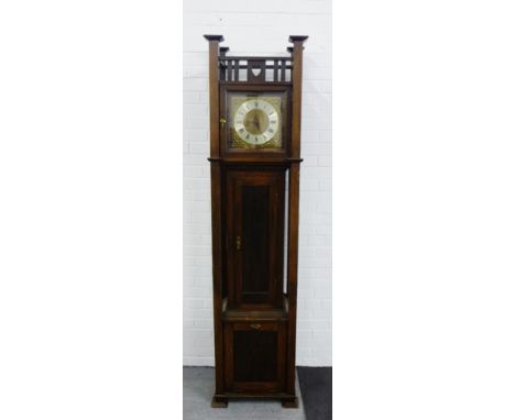 An early 20th century electric clock designed by R.G. Wilson, 1909, contained within an Arts & Crafts oak longcase 214 x 54cm