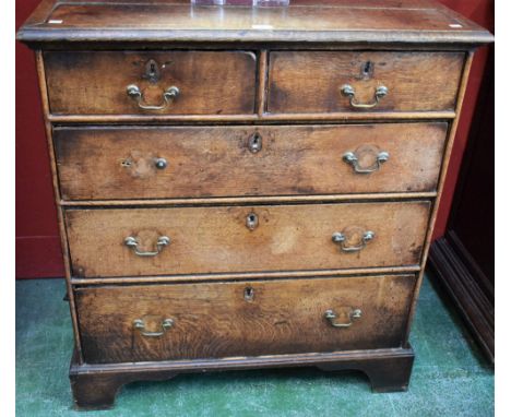 A George III oak chest, slightly oversailing moulded rectangular top above two short and three long graduated drawers, bracke