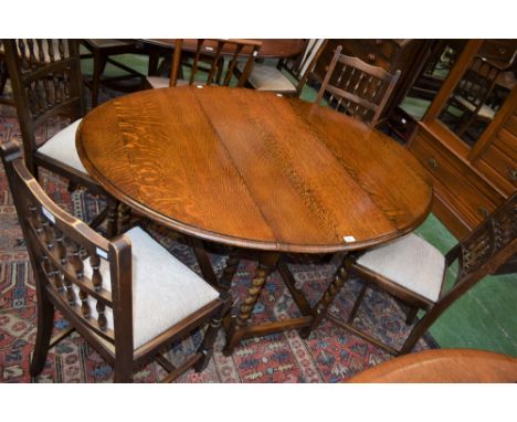 A 20th century oak dining table, elliptical top with fall leaves, spirally turned supports, opening to 147cm; a set of four s