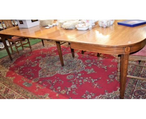 A Sheraton Revival mahogany extending dining table, stadium shaped top with five additional leaves, tapered square legs inlai