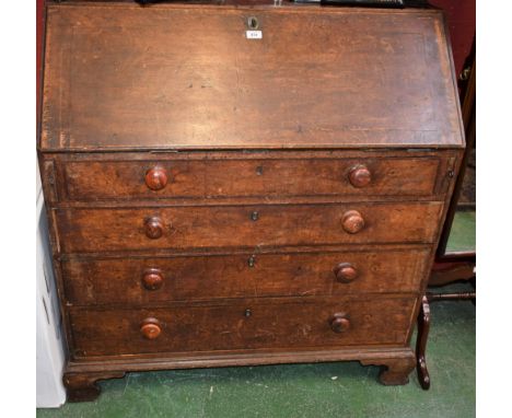 A George III oak bureau, fall front enclosing small drawers, pigeon holes, secret trays and a small cupboard door, above four