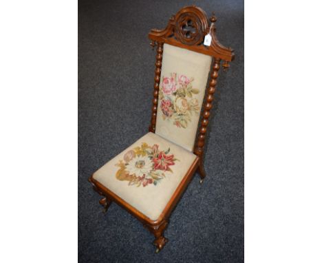 A Victorian Gothic Revival walnut nursing chair, shaped arched cresting pierced with a tracery quatrefoil, above a pair of bo