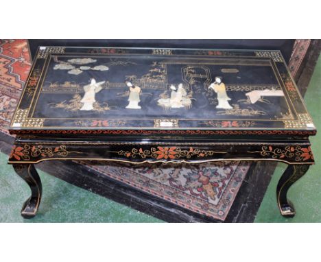 A Chinese inspired lacquer coffee table, rectangular top applied with figures in traditional dress, 107.5cm wide