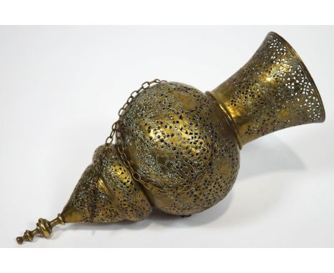 A Middle Eastern brass Islamic Mosque lamp, heavily pierced and engraved with decorative strapwork, with a trumpet top over a
