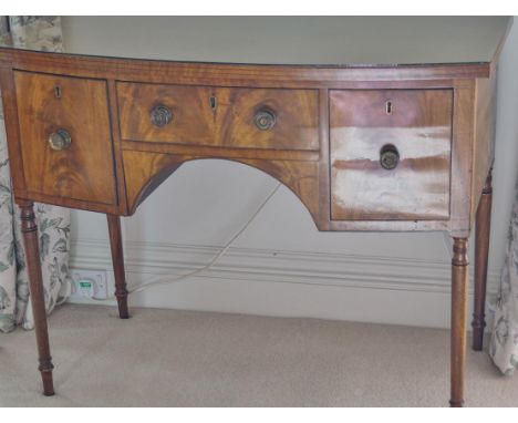 A 19th century bow fronted dressing table with three drawers on turned tapering legs, 85cm high x 107cm wide x 57.5cm deep