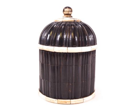 An ebony tea caddy, of ribbed form with hemispherical domed cover, highlighted with worked bone motifs, 14cm high