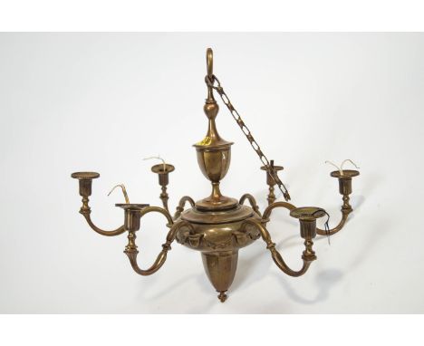 A brass six branch ceiling light suspended from a classical urn over a bulbous motif applied with S scroll branches with reed