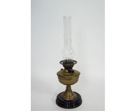 An Art Nouveau brass oil lamp with chimney and china base, 57cm tall