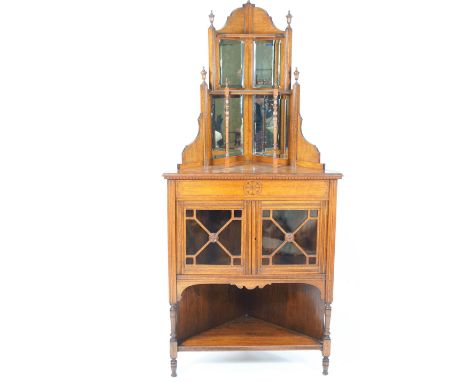 A Victorian mahogany standing corner cabinet, with mirrored back above two glazed doors above an open shelf, 174cm high x 81c