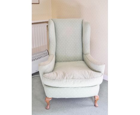 A wing armchair on cabriole legs, upholstered in blue with a loose seat cushion