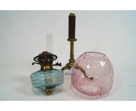 A Victorian oil lamp with blue glass reservoir and pink glass shade, the brass column stand detached
