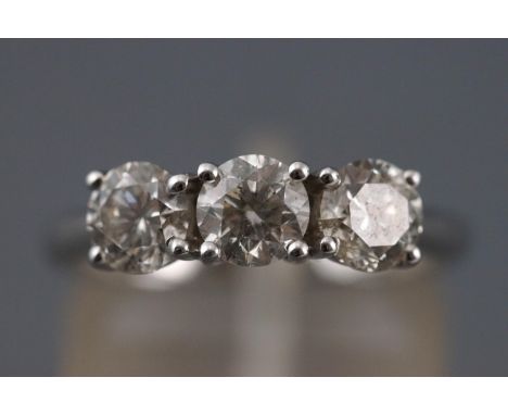 A white metal three stone ring. Set with three round brilliant cut diamonds measuring approximately 5.00mm diameter. Estimate