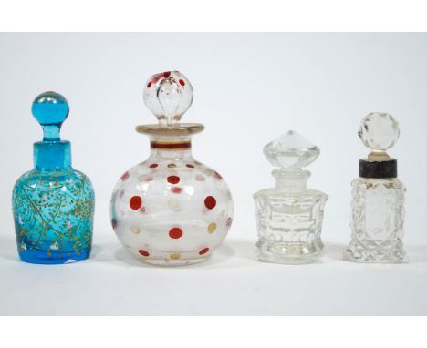 Four glass scent bottles with stoppers, the principal globular one spot decorated in red and white enamel, 8cm high