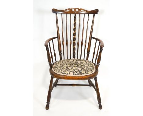 A late 19th century stained hardwood Arts and Crafts armchair with pierced carved and shaped splat over a stick back with cen