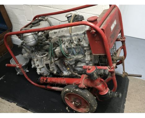 A Vintage Fire Service petrol water pump with detachable hydrant tap and house filters on a red frame. The four cylinder engi