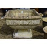 A reconstituted stone square shaped pedestal planter.