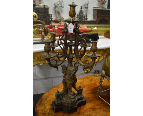 A large pair of decorative cast metal four branch, five light candelabra.