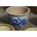 A large glazed planter decorated with a dragon.