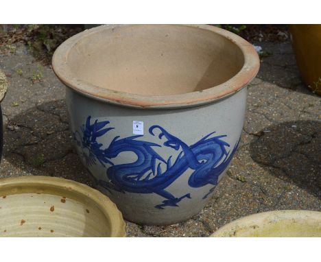 A large glazed planter decorated with a dragon.