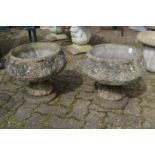 A pair of reconstituted stone pedestal planters.
