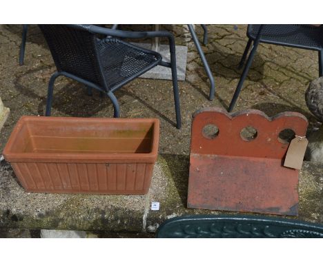 A terracotta ridge tile and a planter.