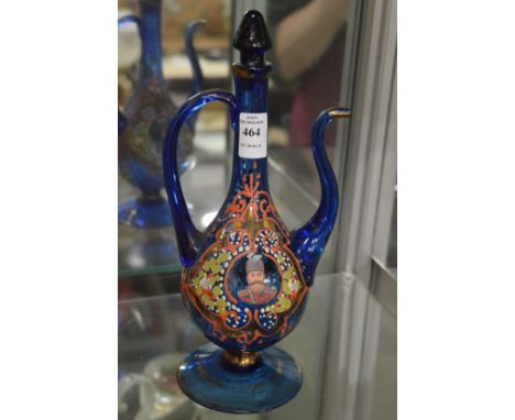 An Islamic blue glass ewer with enamelled portrait decoration.