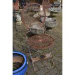 A wrought iron folding garden chair.