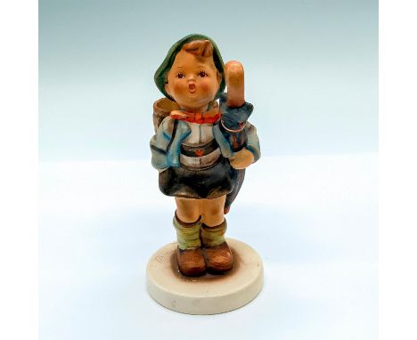 Matte porcelain, hand painted. Young boy with umbrella carrying a pig in a basket. 'M. I. Hummel' inscribed on back of base. 