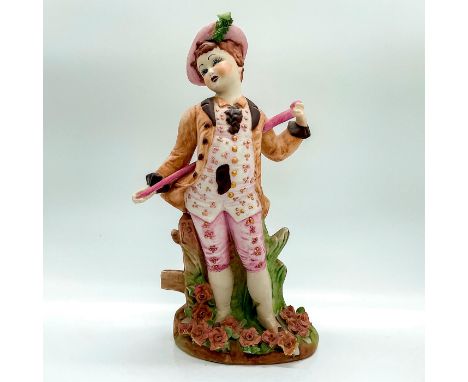Hand made and hand painted in matte finish figure of a colonial boy in pink green and brown outfit standing in a floral garde