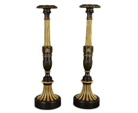 A pair of Regency patinated bronze and parcel gilt torcheresCirca 1820Each with a circular dished top and projecting lappeted