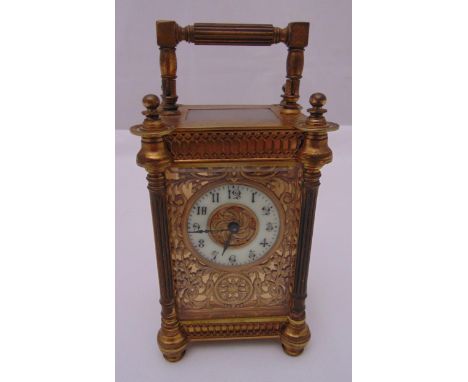 A late 19th century brass carriage clock with fluted columns hinged handle, the enamel dial with Arabic numerals, to include 