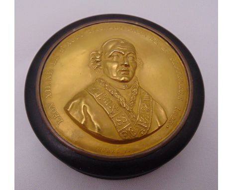 A 19th century circular tortoiseshell and inlaid embossed gold plated snuff box, the pull off cover set with a gold plated em