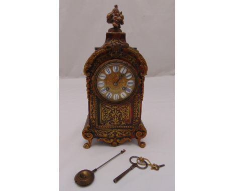 A Boule mantle clock, two train movement with gilded and enamel dial and Roman numerals, floral cluster finial on four scroll