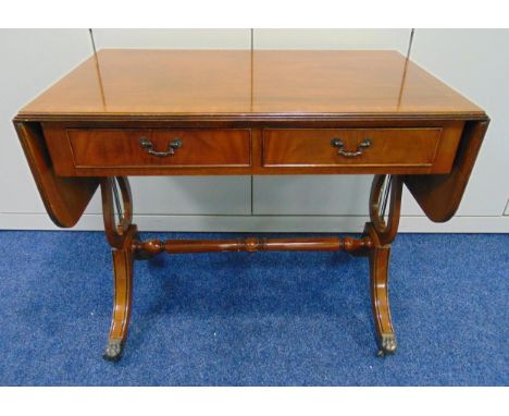 A mahogany rectangular two drawer sofa table with drop flaps on original castors, 74 x 148.5 x 54.5cm