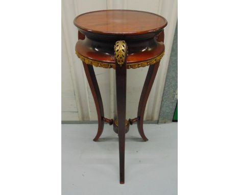 A continental mahogany circular plant stand with brass mounts on three outswept legs, 67 x 31cm