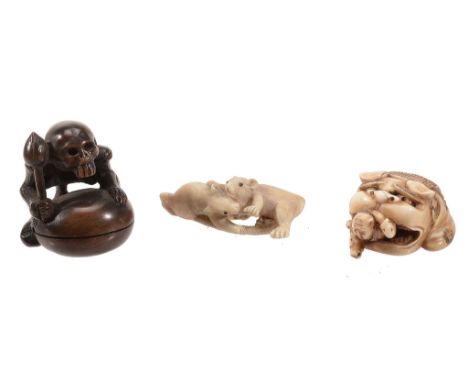 An Ivory Netsuke carved in the form of two boys scrambling out from under a... An Ivory Netsuke carved in the form of two boy