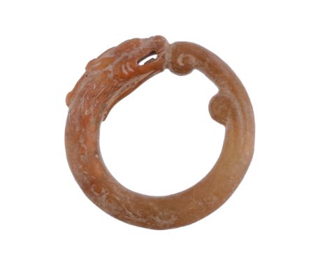 A Chinese Archaistic Jade Pendant, of annular form carved in the yellowish... A Chinese Archaistic Jade Pendant, of annular f