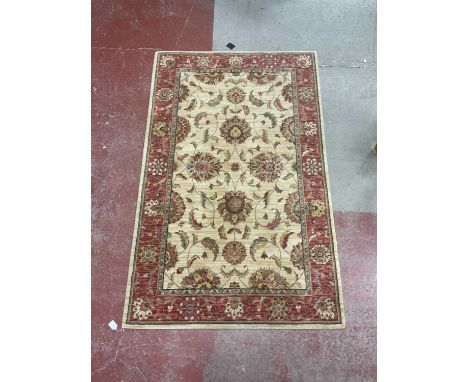 A Wool Rug, with a red ground border and foliage decoration, 106 x 168cm.