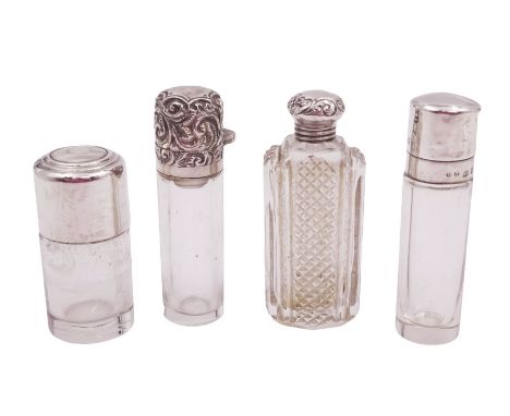 Four silver mounted glass scent bottles, including a Victorian cut glass example with embossed silver cover, and three cylind