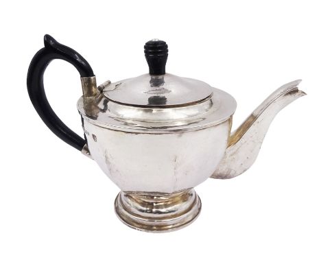 Modern Arts and Crafts style silver teapot, of circular faceted form, with hammered finish and ebonised wooden handle and fin