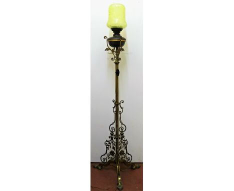 An ornate Victorian standard oil lamp, raised on three legs with scroll, floral and foliate metalwork, with gilt finish, and 