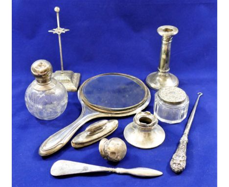 A collection of silver dressing table related items including a silver handled button hook, a small candlestick, an ink well,