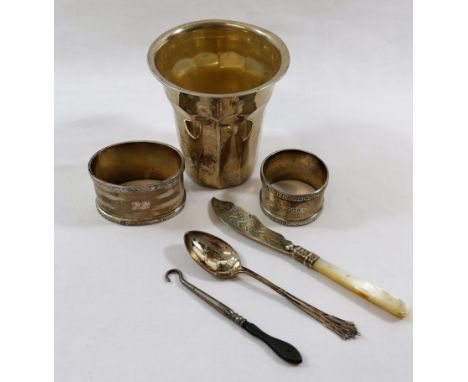 A small quantity of silver items comprised of an oval napkin ring and a small circular napkin ring, a mother of pearl handled