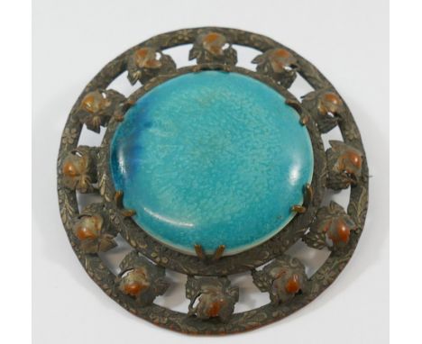 A large circular Ruskin pottery brooch, the turquoise glazed panel marked 'RUSKIN' to the reverse, housed in a silver plated 