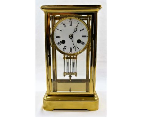 A four-glass brass cased mantle clock with mercury pendulum, the white enamel dial with Roman numerals, striking on a bell, t