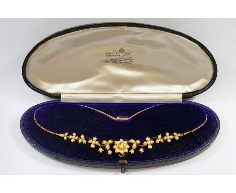 A late Victorian gold and seed pearl mounted floral necklet, with rope twist chain and barrel clasp and hook for additional p
