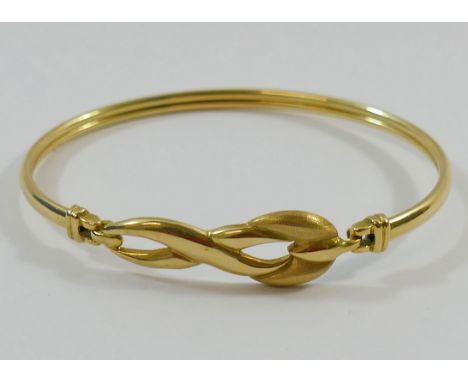 A yellow gold bangle, with stylised twist decoration and part matt finish, stamped '750', 9.7g CONDITION REPORT: If you requi